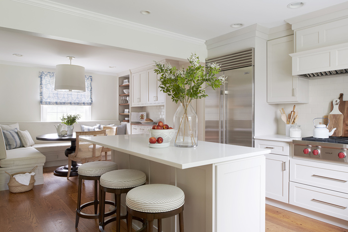 Bright kitchen with island, banquette seating, and built in cabinetry by Glenna Stone Interior Design - Easing pain points at home