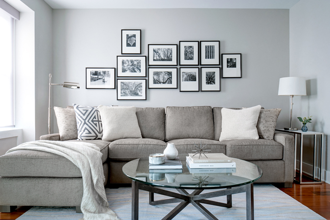 Gray sectional sofa in den with gallery wall by Glenna Stone Interior Design for small space solutions