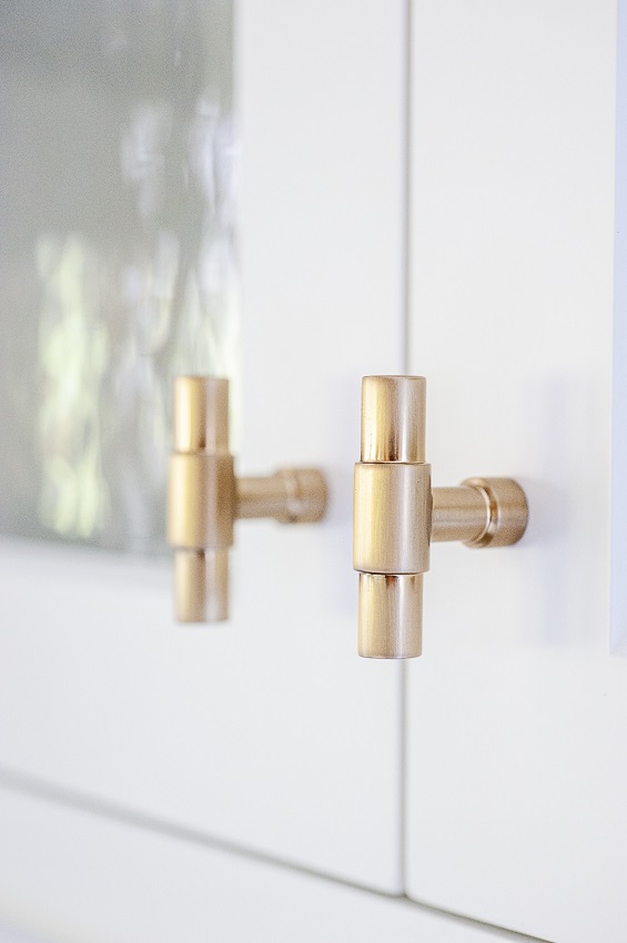 Brass bar cabinet knobs on white cabinets with glass favorite hardware